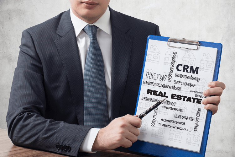 person holding board written how crm in real estate works on it.