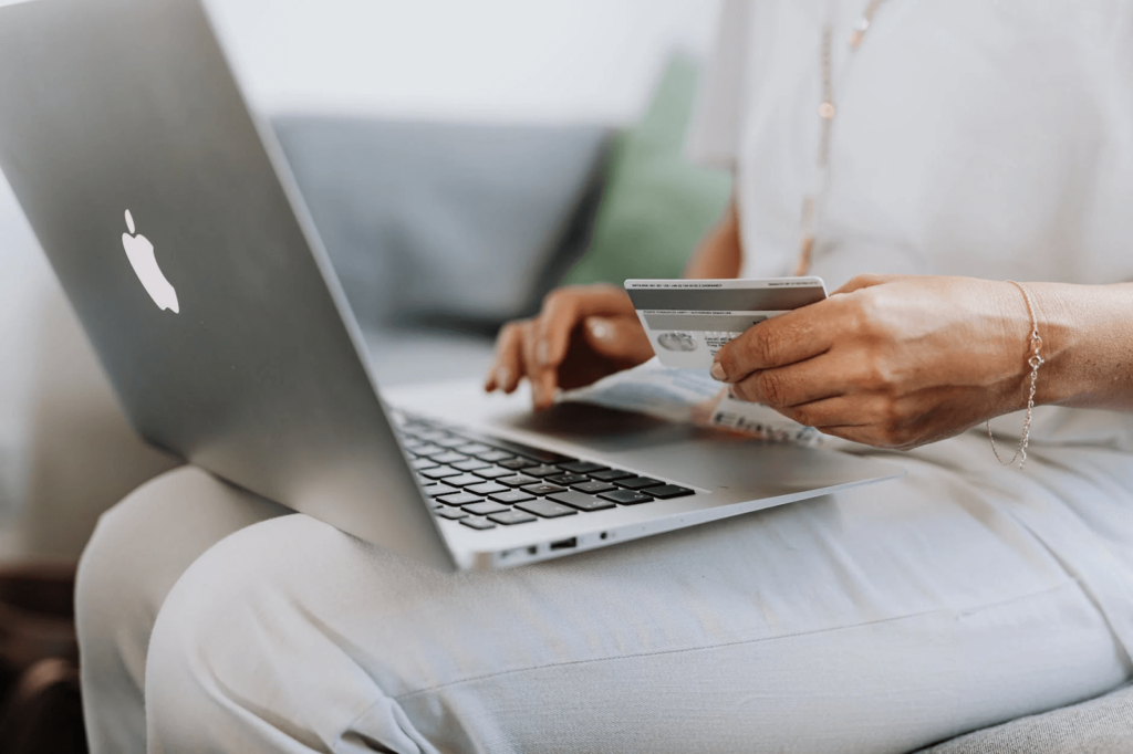 lady doing online payment via card with laptop in her lap