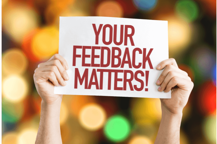 hands holding your feedback matters card with colorful lights in background