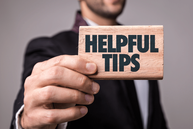 men holding wooden block written helpful tips on it