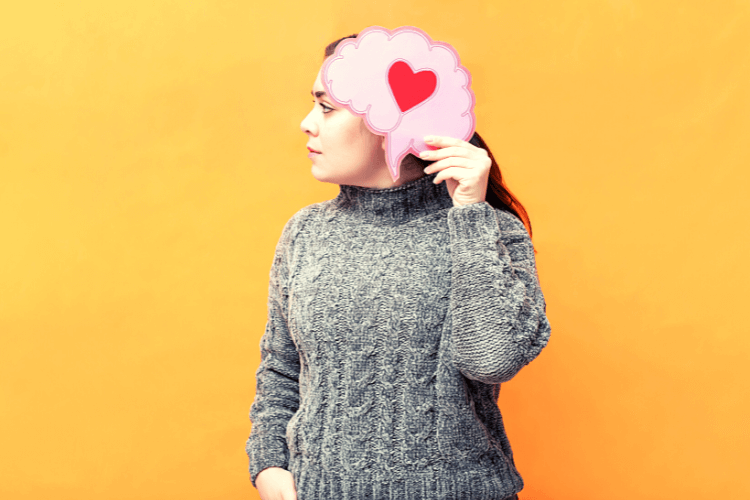 women holding pink brain with heart made inside the brain signifying emotional intelligence 