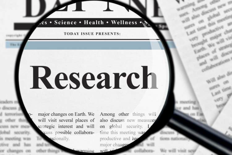 magnified Research word on newspaper signifying manual market research
