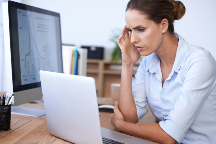 women sitting with desktop and laptop with critical thinking and confusion face