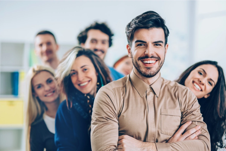 a dynamic leader smiling, and the team members are standing behind the leader side by side