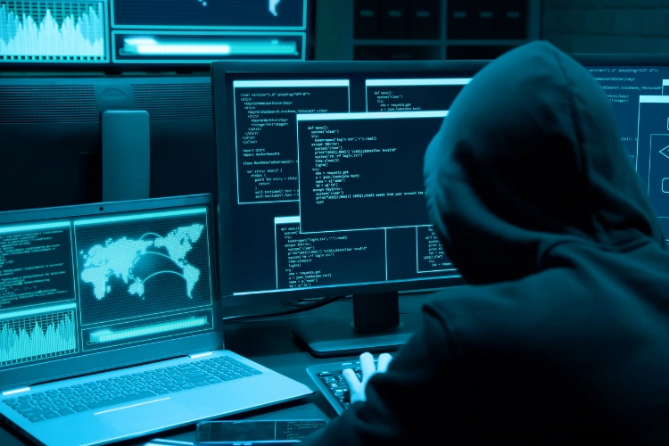 hacker in black sweatshirt running code on computer