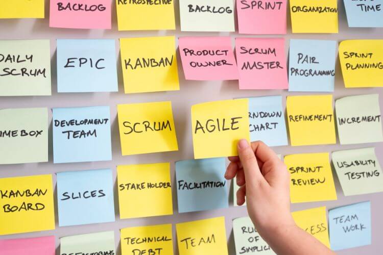 A person displays sticky notes with the word "Agile" particularly written on them