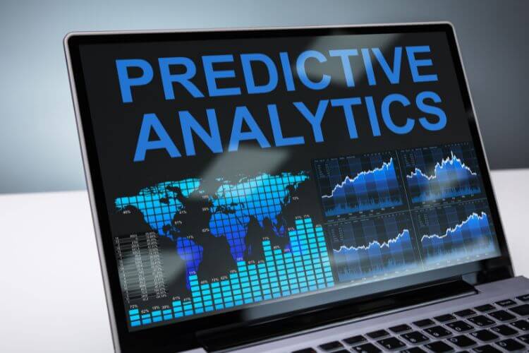 Laptop screen displaying "Predictive Analytics" with a world map and data charts.