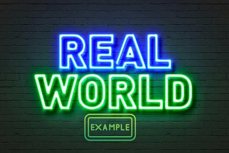 Neon sign against a dark brick wall reads "REAL WORLD" in blue and green