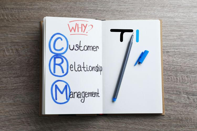 In a notebook showcasing the title " customer relationship management" and on right size a image of a black ball that has drawn Technicali Logo TI.