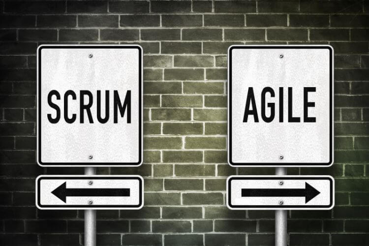 Two road signs against a brick wall read "SCRUM" with a left arrow and "AGILE" with a right arrow