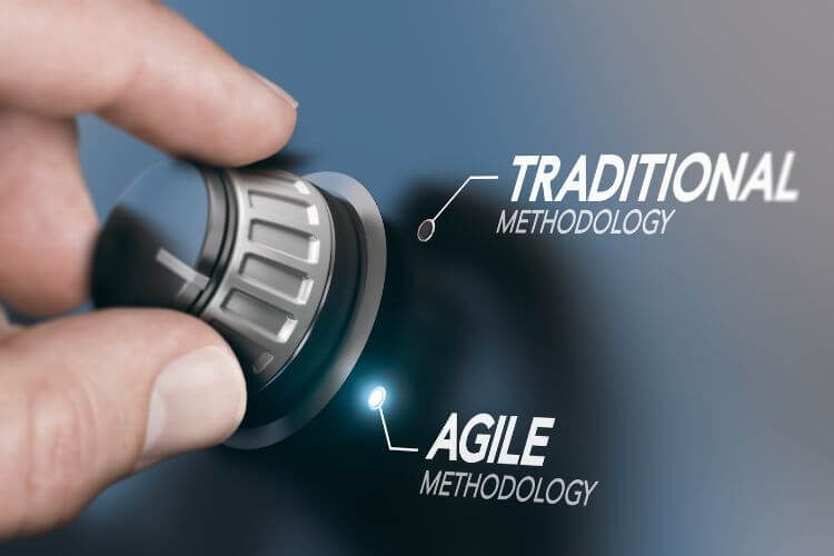 A hand adjusts a dial on a sleek surface, switching from "Traditional Methodology" to "Agile Methodology