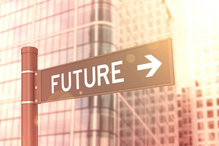 Sign with the word "Future" and an arrow pointing right, set against modern glass buildings.